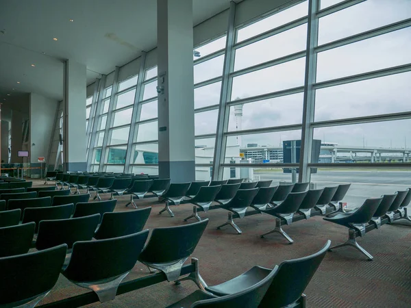 Havaalanı sandalye alan Jet köprü manzaralı bekliyor. Büyük Havaalanı bekleme odasında Kuala Lumpur Havaalanı