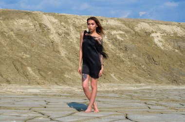 Çölde siyah elbiseli Asyalı bir kız.