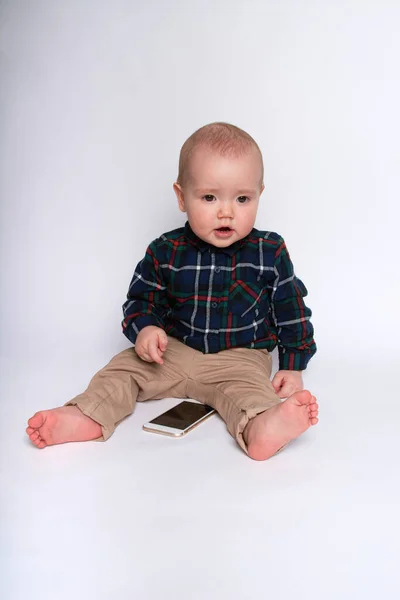 Lille Dreng Smiler Holder Smartphone Hvid Baggrund - Stock-foto