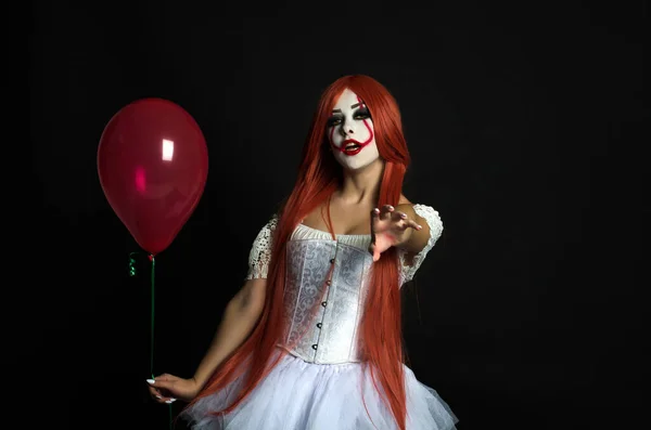 Een meisje in een clown kostuum met eng make-up — Stockfoto
