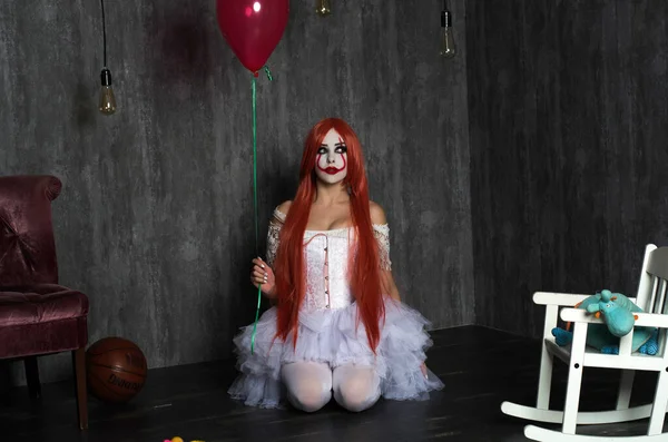 Een meisje in een clown kostuum met eng make-up — Stockfoto