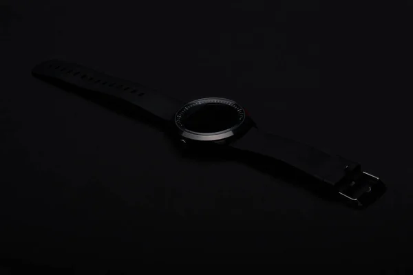 Elektronické náramkové hodinky s černým popruhem na černém pozadí — Stock fotografie