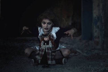 Terk edilmiş bir evde oyuncak bebeği olan korkunç bir kız.