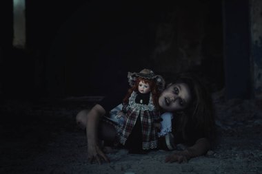 Terk edilmiş bir evde oyuncak bebeği olan korkunç bir kız.