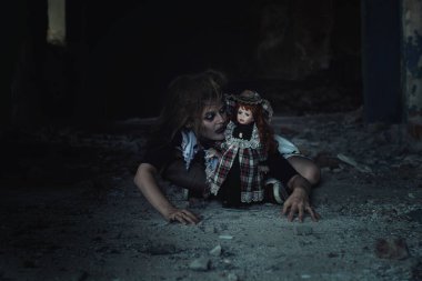 Terk edilmiş bir evde oyuncak bebeği olan korkunç bir kız.