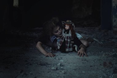 Terk edilmiş bir evde oyuncak bebeği olan korkunç bir kız.