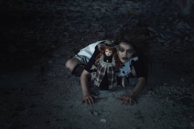 Terk edilmiş bir evde oyuncak bebeği olan korkunç bir kız.