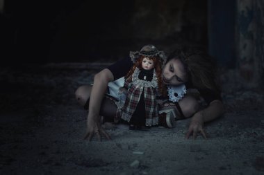 Terk edilmiş bir evde oyuncak bebeği olan korkunç bir kız.