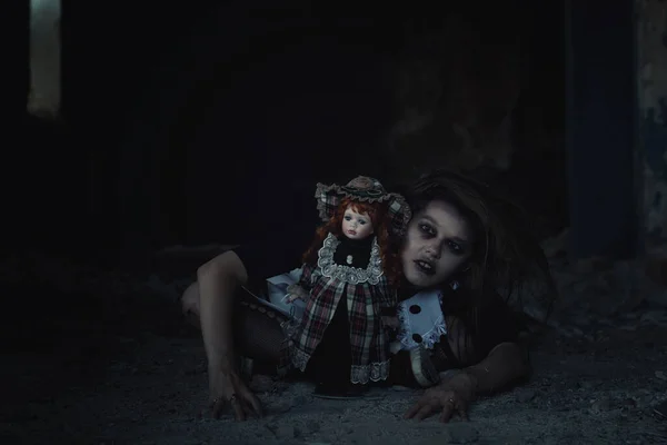 scary girl with a doll in an abandoned house