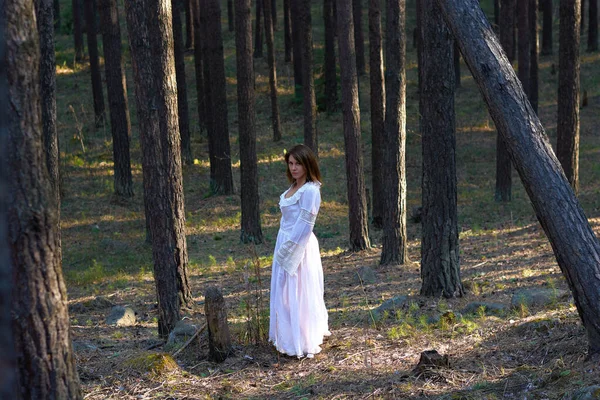 日落时穿着白衣的女孩在森林里 — 图库照片