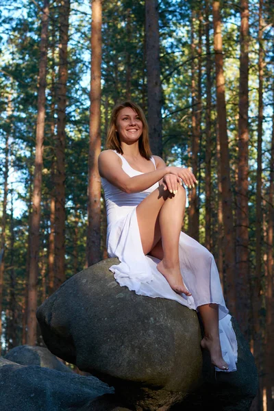 Ένα Κορίτσι Λευκό Φόρεμα Κάθεται Ένα Βράχο Στο Δάσος Στο — Φωτογραφία Αρχείου