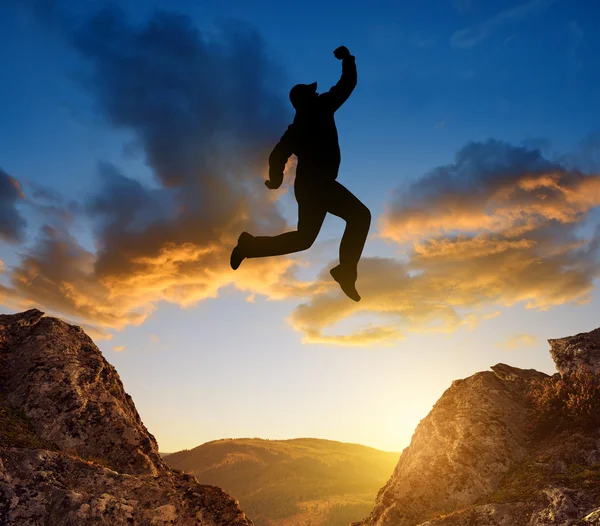 Silhouette tourist jumping over the gap — Stock Photo, Image