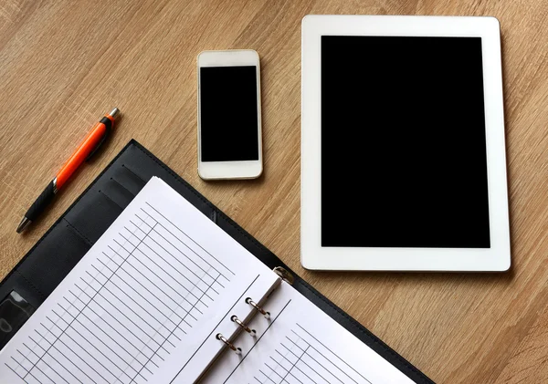 Libro abierto, tableta y smartphone en el escritorio . — Foto de Stock