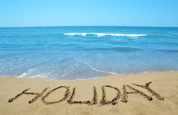 Holiday written on sandy beach — Stock Photo, Image