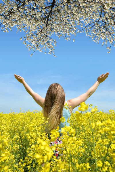 Young happy woman in the rapeseed field