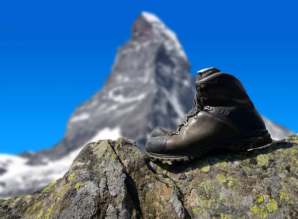 在岩石上，在背景山马特宏峰的徒步旅行鞋 — 图库照片
