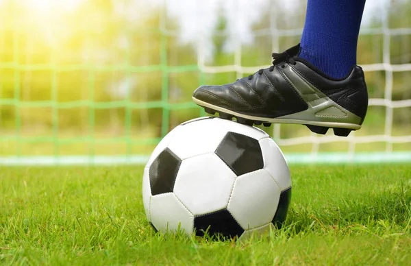 Soccer ball and foot of football player. — Stock Photo, Image