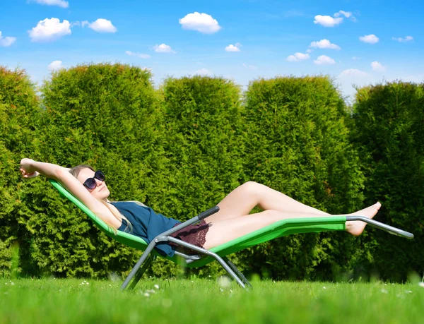 Mulher relaxante na espreguiçadeira . — Fotografia de Stock