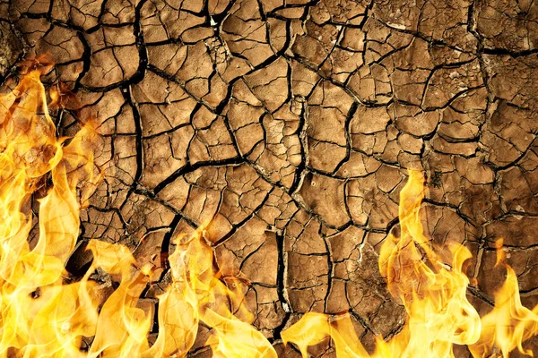 Cracked dry soil of earth texture with fire flames. — Stock Photo, Image