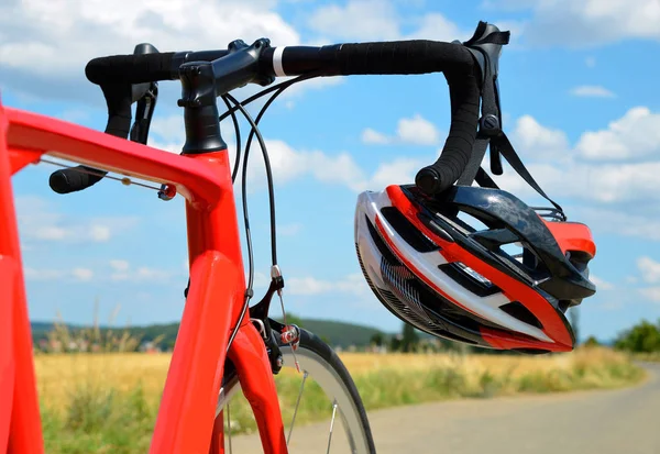 Helmet on the road bike handlebars. — Stock Photo, Image