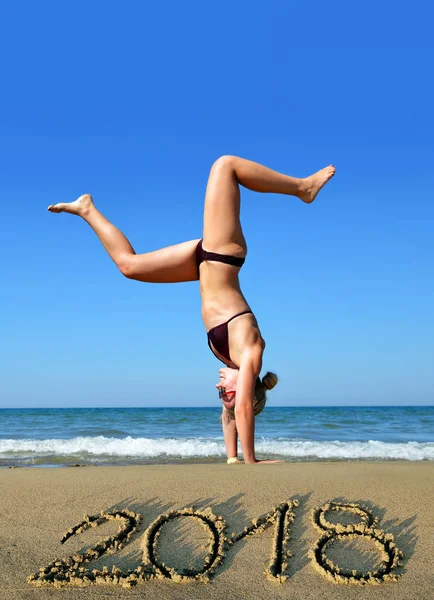 Mulher na praia junto ao mar enquanto celebra o Ano Novo 2018 . — Fotografia de Stock