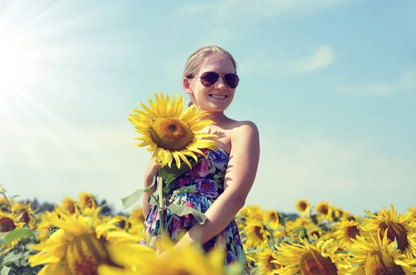 Mooi meisje op de zonnebloem gebied. — Stockfoto