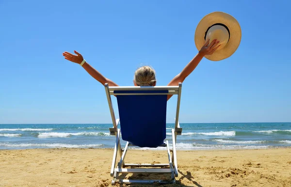 Meisje liggend op een ligstoel aan zandstrand. — Stockfoto