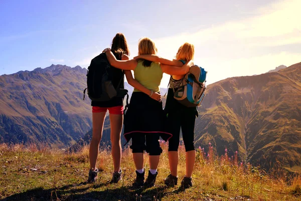 Três turistas olham para a paisagem alpina . — Fotografia de Stock