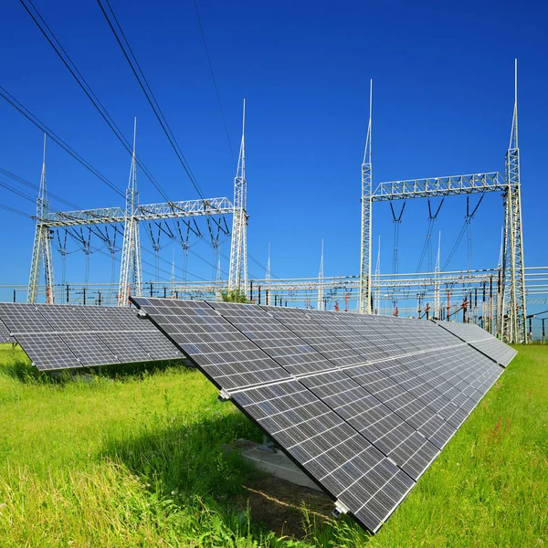 Paneles de energía solar en la subestación de energía de alto voltaje de fondo . —  Fotos de Stock