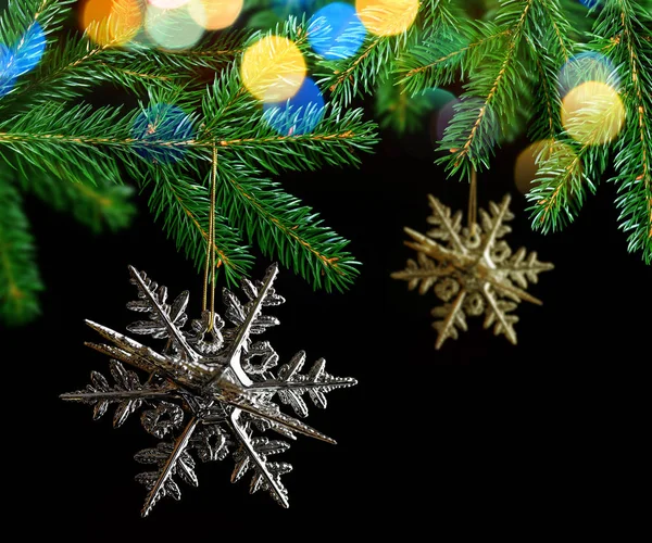 黒い背景にモミ枝に掛かっている図形スノーフレークのクリスマス装飾 — ストック写真