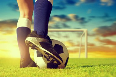 Futbol topuyla ayak oyuncu günbatımı futbol sahasının.
