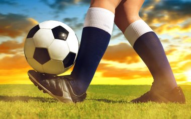 Futbol topuyla ayak oyuncu günbatımı futbol sahasının.
