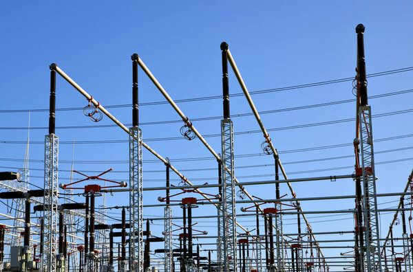High voltage power substation on blue sky background.