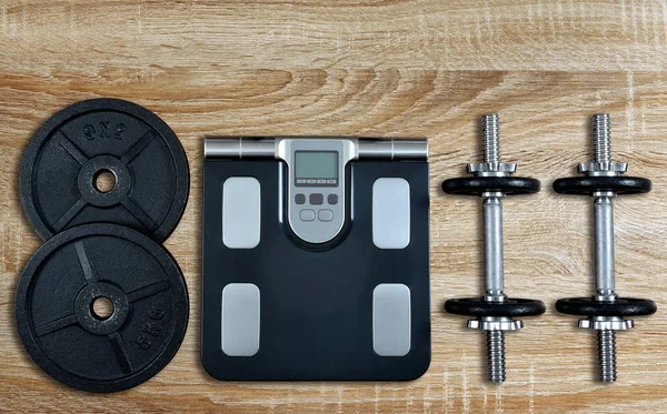 黑色哑铃与金属圆盘和体重秤在健身房 健康的生活方式概念 — 图库照片