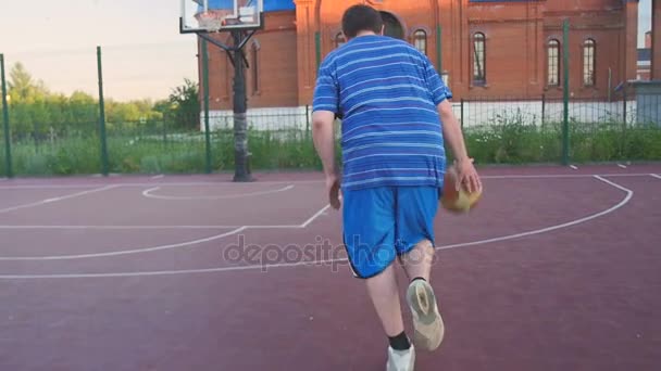 Junger Kerl spielt Straßenbasketball — Stockvideo