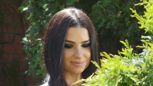 La chica en el jardín mirando al árbol — Vídeos de Stock