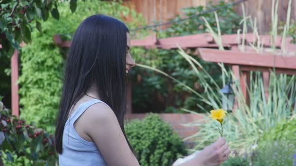 Amare ragazza con un fiore nel parco — Video Stock