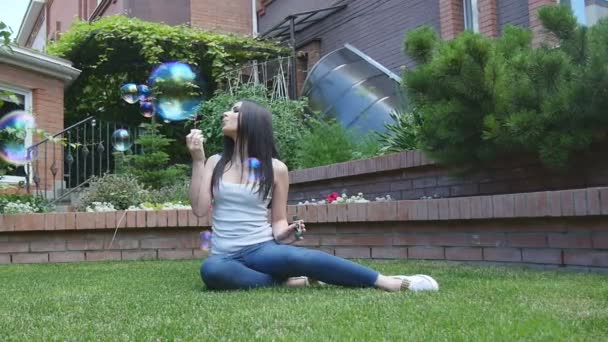 लड़की गार्डन में साबुन बुलबुल उड़ाती है — स्टॉक वीडियो