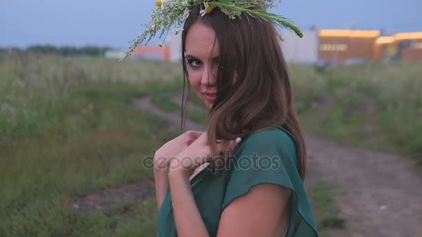 Chica con flores en el campo sonriendo a la cámara — Vídeos de Stock