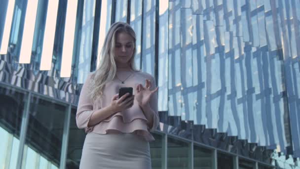 La chica con el teléfono cerca de la oficina — Vídeo de stock