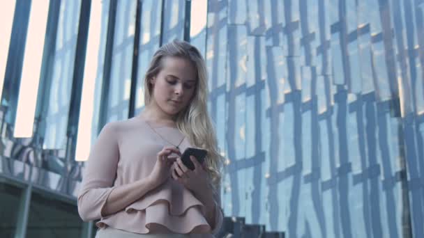 La chica con el teléfono cerca de la oficina — Vídeo de stock