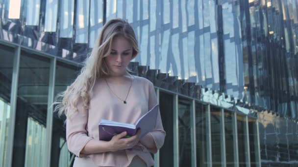 Chica con un Bloc de notas cerca de la Oficina — Vídeo de stock