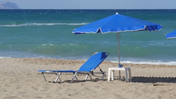 Leere Chaiselongue unter Sonnenschirm an der Meeresküste — Stockvideo