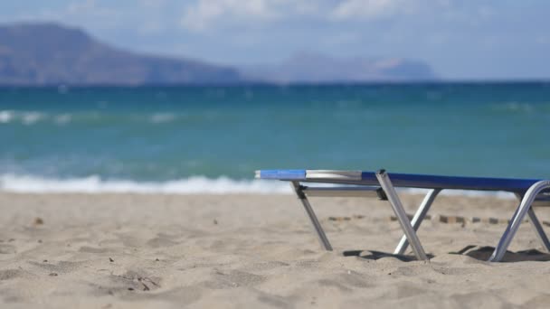 在海洋海岸上的太阳伞下的空贵妃椅。 — 图库视频影像