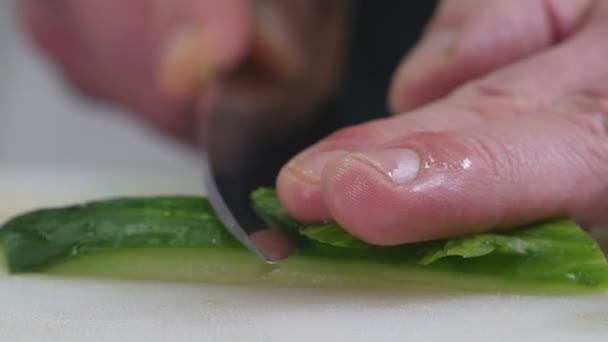 Профессиональный повар на кухне режет огурец — стоковое видео