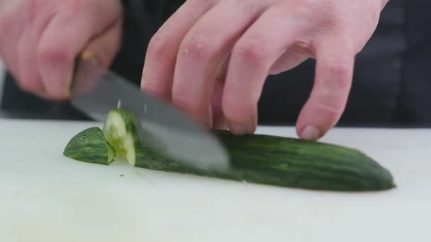 Шеф-повар на кухне, нарезанный огурец — стоковое видео
