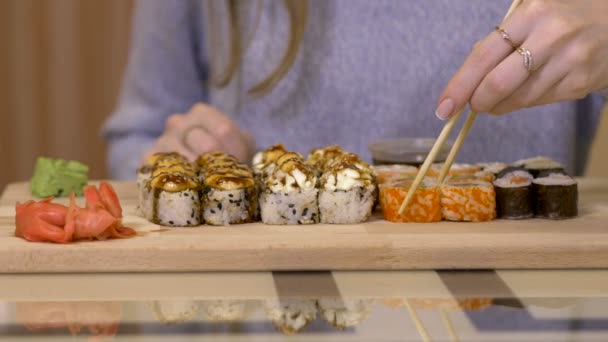 Mladá dívka jíst Sushi hůlkami — Stock video