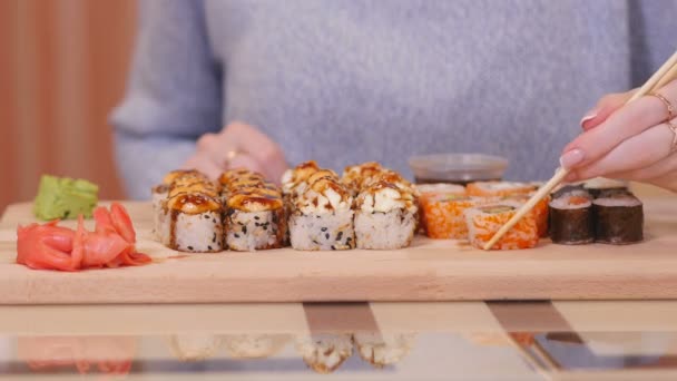 Mädchen isst Sushi in Sauce in Sushi-Bar, Nahaufnahme. — Stockvideo