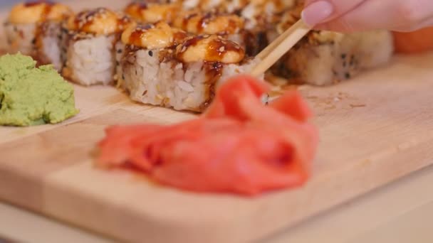 Vrouw Hand met stokjes dompelen Sushi Roll in sojasaus. 4k — Stockvideo