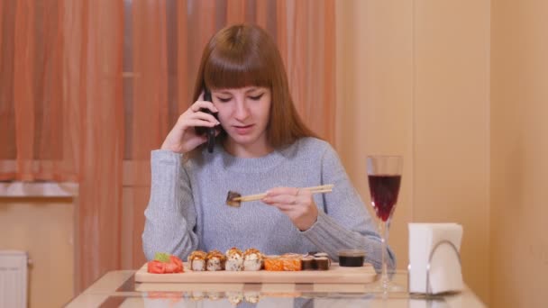 Adolescente chica rollos y chats en el teléfono — Vídeos de Stock